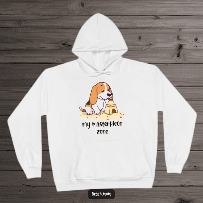 Funny Basset Hound hoodie with a dog in deep concentration, building a small, intricate sandcastle.
