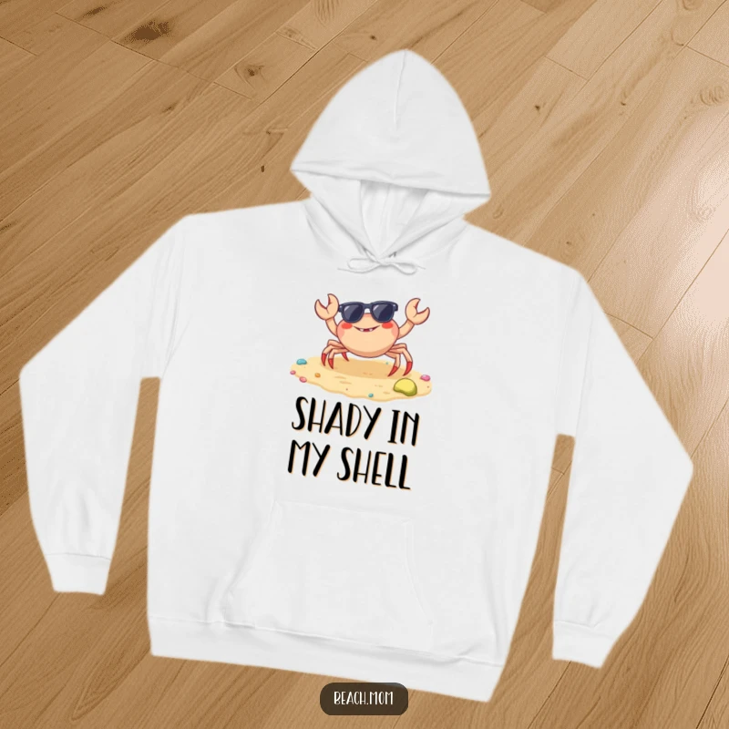 Funny crab hoodie showcasing a cheerful crab with sunglasses on a colorful beach, offering warmth and laughter.