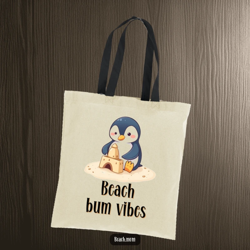 Funny penguin using tiny flippers to build a sandcastle, featured on a durable tote bag, embodying quirky beach fun.